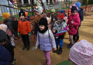 Dzieci witają wiosnę w ogródku przedszkolnym.