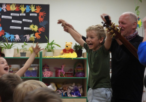 Muzycy śpiewają wspólnie z dziećmi.
