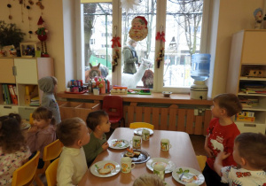 Dzieci głaszczą i przytulają alpaki.