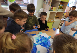 Dzieci przygotowują dekorację do obchodów Tygodnia Autyzmu.