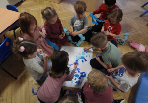 Dzieci przygotowują dekorację do obchodów Tygodnia Autyzmu.