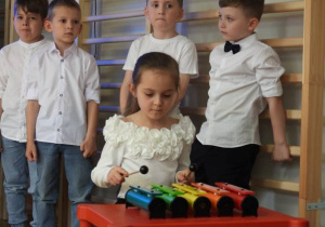 Dziewczynka gra na cymbałakach.