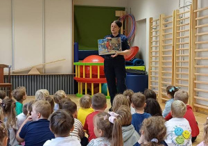 Dzieci słuchają o czym opowiada Strażnik Miejski.