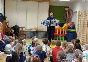 Dzieci słuchają o czym opowiada Strażnik Miejski.