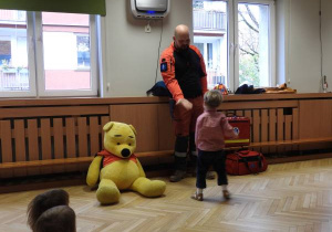 Ratownik medyczny wita się z dzieckiem.