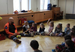 Ratownik medyczny opowiada dzieciom o udzielaniu pierwszej pomocy.