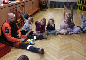 Ratownik medyczny opowiada dzieciom o udzielaniu pierwszej pomocy.