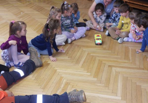 Ratownik medyczny opowiada dzieciom o udzielaniu pierwszej pomocy.