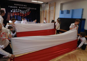 Dzieci prezentują flagę narodową.