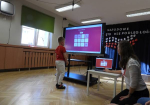 Chłopiec rozwiązuje quiz na tablicy multimedialnej.