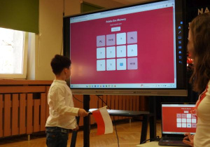 Chłopiec rozwiązuje quiz na tablicy multimedialnej.