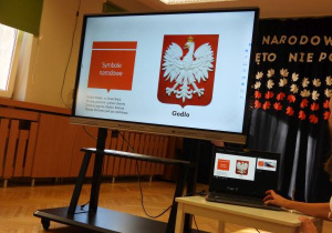 Tablica multimedialna z symbolami narodowymi.