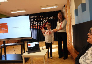 Dziewczynka rozwiązuje quiz na tablicy multimedialnej.