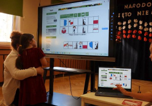 Dziewczynka rozwiązuje quiz na tablicy multimedialnej.