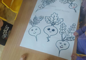 Dzieci kolorują kolorowankę.