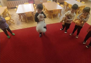 Dzieci siedzą na dywanie.