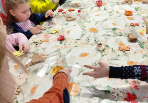 Dzieci malują farbami ozdoby świąteczne.