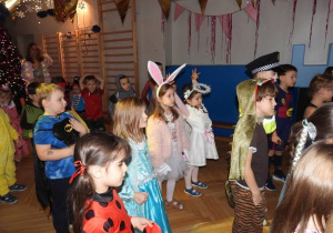 Dzieci tańczą na balu karnawałowym.