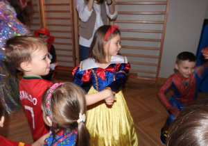 Dzieci tańczą na balu karnawałowym.