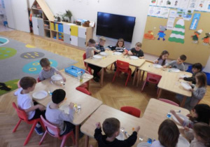 Dzieci przeprowadzają doświadczenia podczas warsztatów badawczych Klubu Dociekliwego Przedszkolaka.