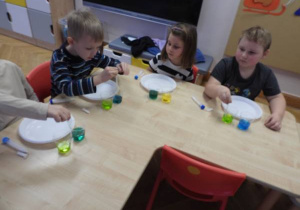 Dzieci przeprowadzają doświadczenia podczas warsztatów badawczych Klubu Dociekliwego Przedszkolaka.