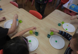 Dzieci przeprowadzają doświadczenia podczas warsztatów badawczych Klubu Dociekliwego Przedszkolaka.