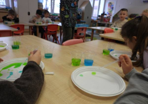 Dzieci przeprowadzają doświadczenia podczas warsztatów badawczych Klubu Dociekliwego Przedszkolaka.