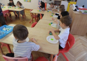 Dzieci przeprowadzają doświadczenia podczas warsztatów badawczych Klubu Dociekliwego Przedszkolaka.