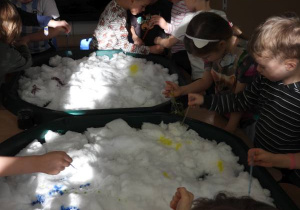 Dzieci malują na śniegu.