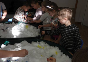 Dzieci malują na śniegu.