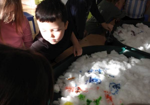 Dzieci malują na śniegu.