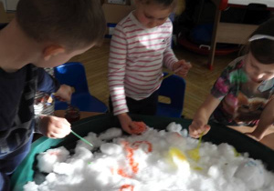 Dzieci malują na śniegu.