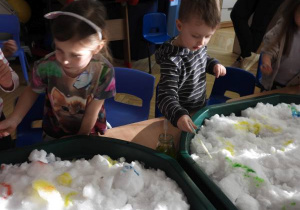 Dzieci malują na śniegu.