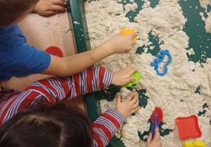 Dzieci bawią się materiałem sensorycznym.