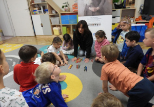Dzieci kolorują obrazek Olgi Boznańskiej „Dziewczynka z chryzantemami”.